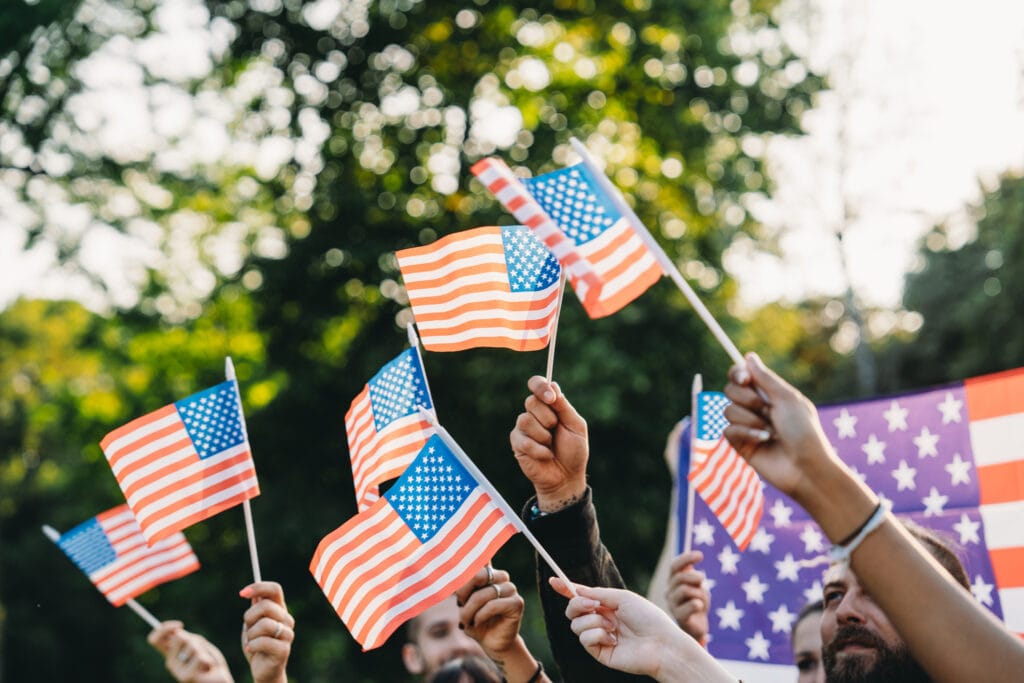 people waving flags at a memorial day parade