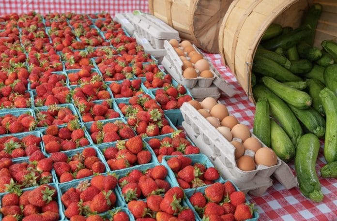 Strawberries, eggs, and vegetables sold at a farmer's market booth at the North Attleboro Farmers Market 